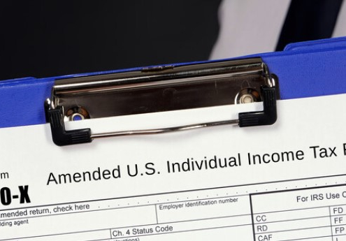 clipboard holding a 1040-x amended income tax return_canstockphoto90132948 845x345