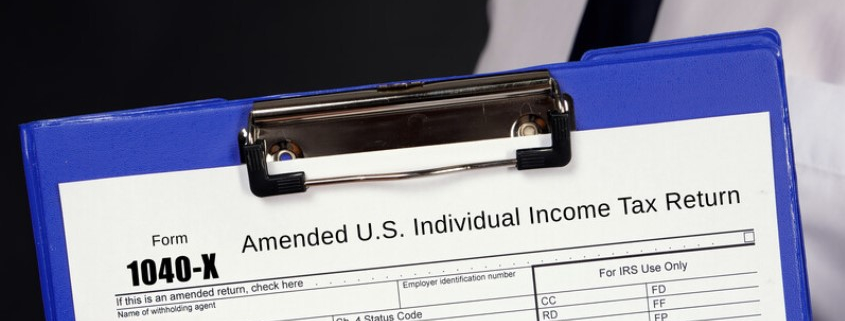 clipboard holding a 1040-x amended income tax return_canstockphoto90132948 845x345